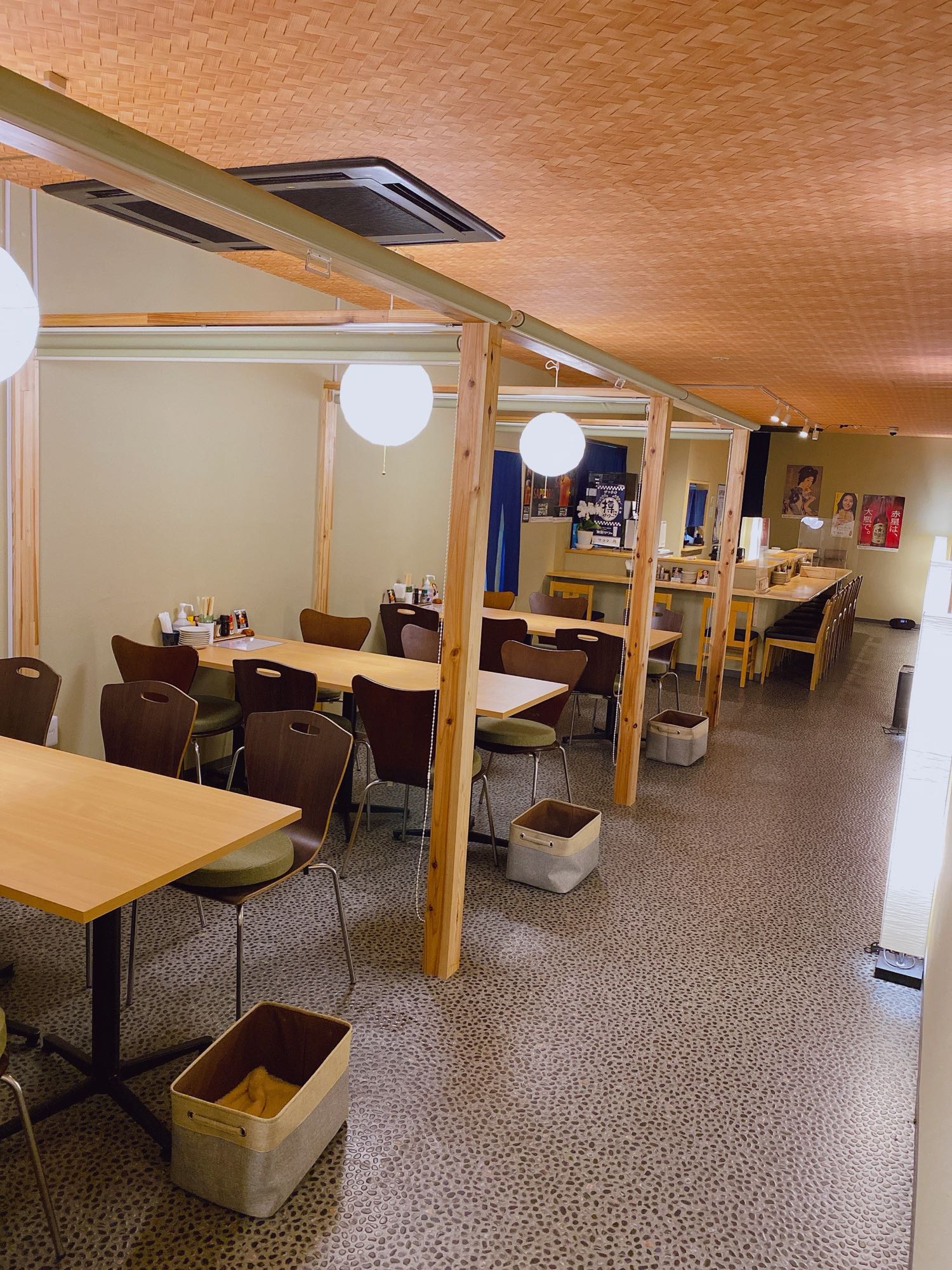 しっぽり亭のテーブル席。木の柱と提灯のあるにぎやかな店内